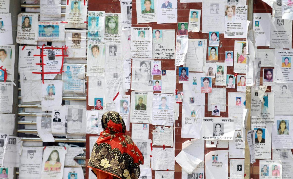 a_woman_looks_at_a_wall_filled_with_portraits_of_missing_people_on_may_3_2013_near_the_collapsed_rana_plaza_building._photo_ashraful_alam_tito_associated_press